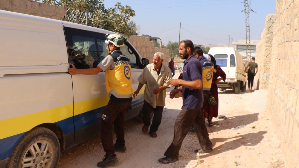Volunteers with the Syria Civil Defense assist three people, a child, his uncle and his aunt, who suffered injuries after a dud submunition exploded in front of their house on October 7, in the city of Termanin, Syria. 