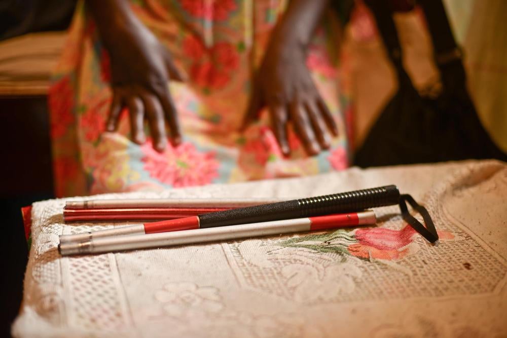 Cheptoo M., a blind woman, displays her walking cane. 