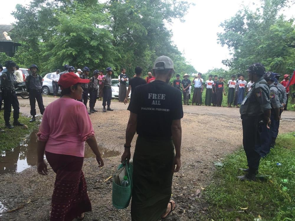 Supporters and police officers await the departure of detained student activists from the Pegu district courthouse as they return to prison on October 27, 2015. 