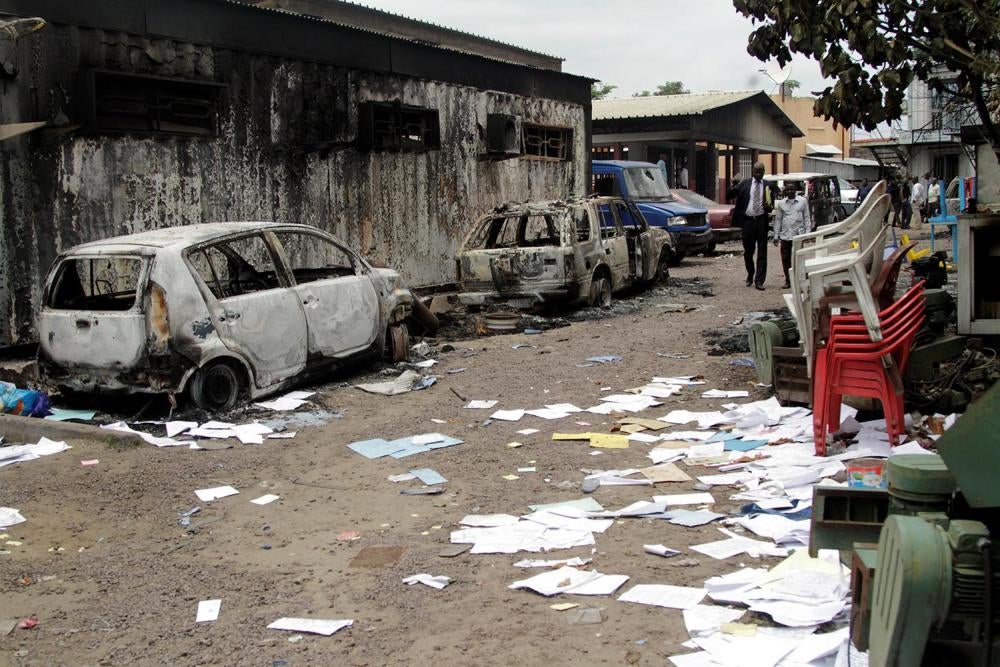 Residents walk past a house and vehicles that were burned during anti-government protests to press President Joseph Kabila to step down, Kinshasa, Democratic Republic of Congo, September 21, 2016. 