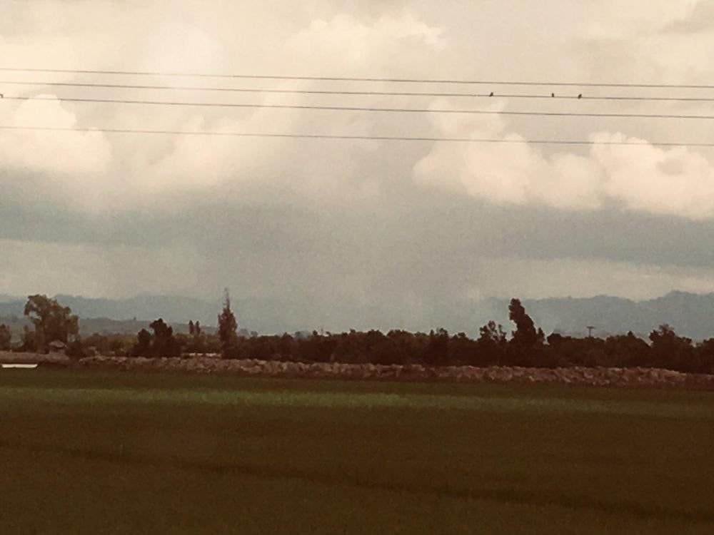 Smoke is seen rising from a village burning across the border in Burma.