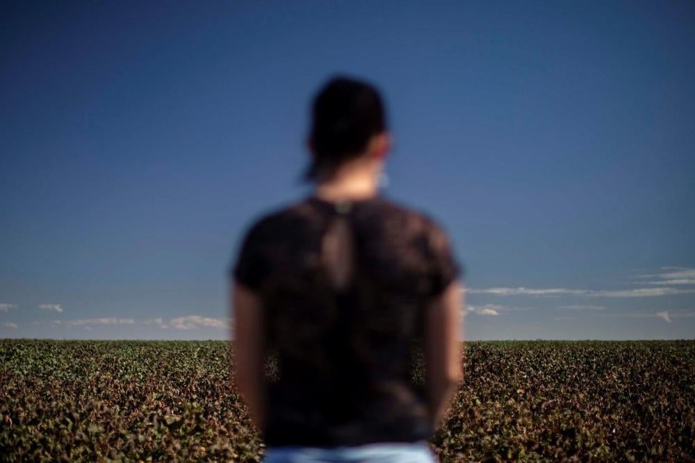 Carina, a women in her mid-30s who studies at a school in the municipality of Primavera do Leste, Mato Grosso, stands near a cotton plantation. Carina suffered acute poisoning while attending school in 2017: “I started feeling sick, nauseous…. I started v