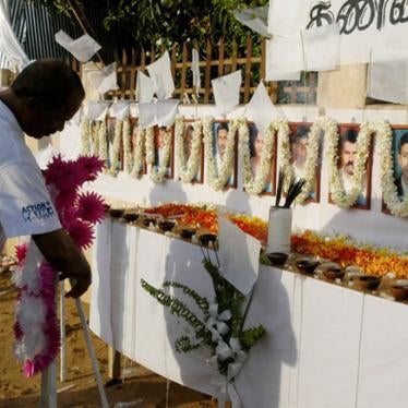 A member of the French aid group Action Contre La Faim places a wreath in front of the photographs of his 17 slain colleagues at their memorial in Batticaloa, Sri Lanka on August 11, 2006.