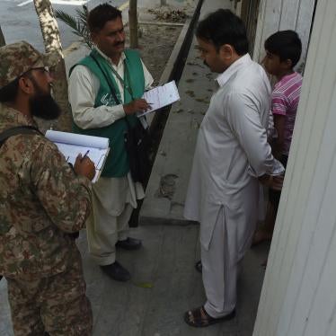 A Pakistan Bureau of Statistics official and a soldier collect census information from an Ahmadi resident in Rabwah, Punjab, Pakistan in March 2017. © 2017 ARIF ALI/AFP via Getty Images