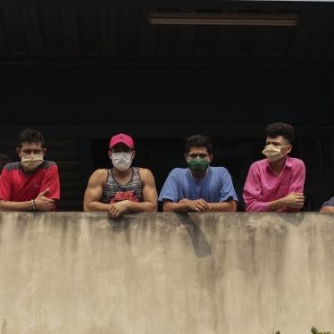 En esta imagen del 4 de mayo de 2020, un grupo de hombres con mascarilla miran desde el edificio donde están siendo confinados por violar la cuarentena decretada por el gobierno, como parte de las medidas para prevenir la propagación del Covid-19, en San Salvador, El Salvador.