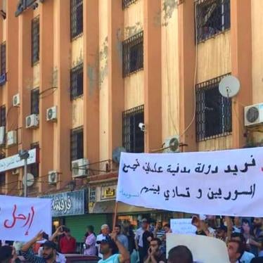 People hold up banners at a protest in Sweida on June 9, 2020 