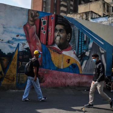 Individuos con mascarillas caminan al lado de un mural con una imagen de Nicolás Maduro en Caracas, el 17 de abril de 2020, en medio de un brote del nuevo coronavirus (COVID-19)