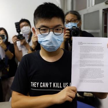 Hong Kong pro-democracy activist Joshua Wong shows his disqualification notice during a press conference in Hong Kong