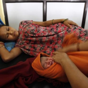 A health worker wraps a baby born minutes before as the mother looks on at the government maternity hospital in Katmandu, Nepal, September 10, 2010.
