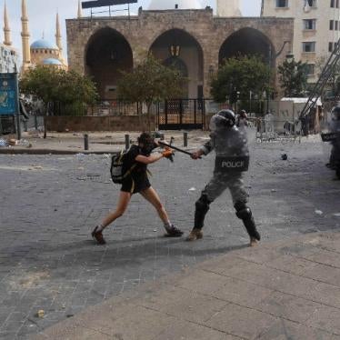 A policeman strikes a protester during anti-government demonstrations on August 8, 2020 in Beirut, Lebanon.