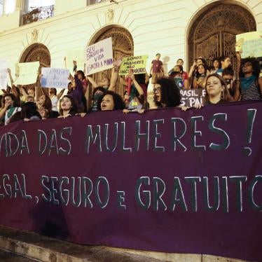 Women hold a banner calling for “legal, safe and free abortion,”