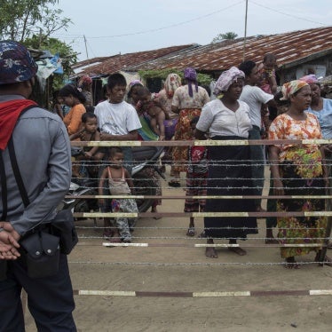 A Myanmar police officer patrols a camp.