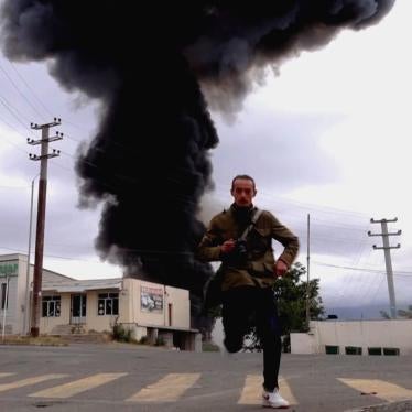 Man running from impact zone of explosive weapon in Nagorno-Karabakh