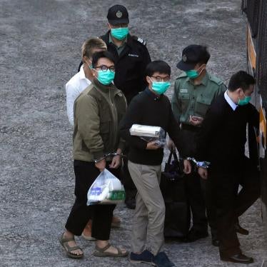 Joshua Wong, center right, and Ivan Lam, center left, were led into a prison van before their court appearance in Hong Kong on Wednesday.