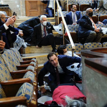 People shelter in the House gallery as protesters try to break into the House Chamber at the U.S. Capitol on Wednesday, Jan. 6, 2021, in Washington.