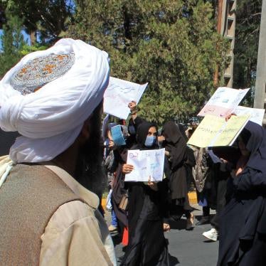 A Taliban member watches as women demonstrate for human rights in Herat, Afghanistan, September 2, 2021. 