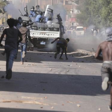 Men run towards an armored police vehicle