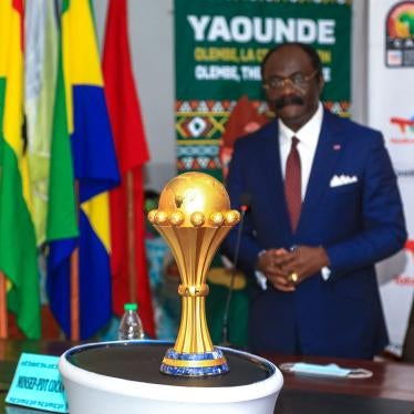 A man stands behind a gold trophy