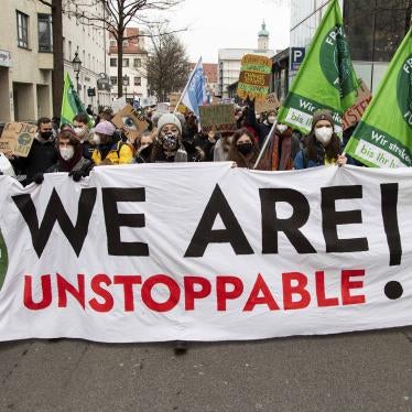 Protesters march with a banner that reads "We Are Unstoppable!"