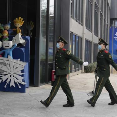 Chinese paramilitary police march past mascots from prior Winter Olympics displayed at Shougang Park in Beijing, China, January 21, 2022. © 2022 AP Photo/Ng Han Guan