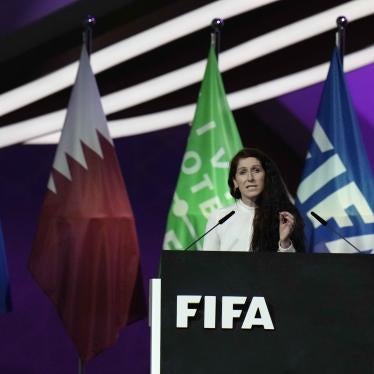 A woman speaks at a podium labeled "FIFA"