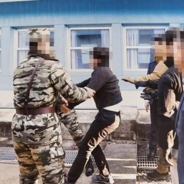 Guards drag a man at the border between North and South Korea