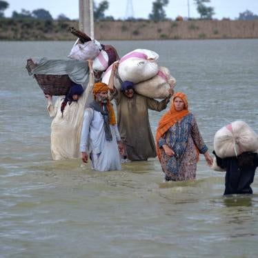 A displaced family wades through a flooded area after heavy rainfall in Jaffarabad, in Pakistan's southwestern Balochistan province.