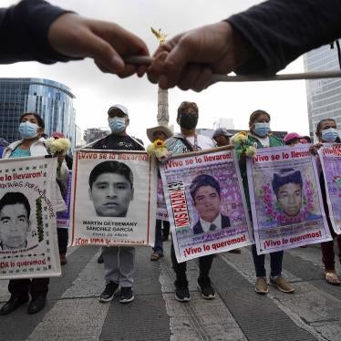 People march with placards showing faces of missing people