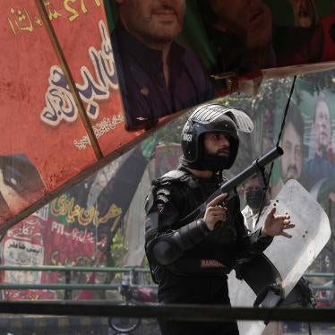 A riot police officer looks on after firing tear gas to disperse supporters of former Prime Minister Imran Khan during clashes in Lahore, Pakistan, March 15, 2023.