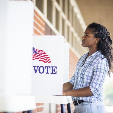A young black woman voting on election day. 