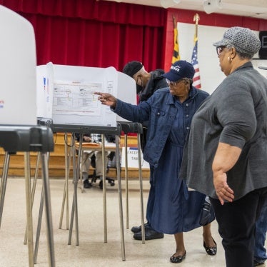 Election workers help voters on the state's primary election day at Lewisdale Elementary School in Chillum, Maryland, May 14, 2024.