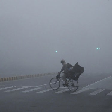 A cyclist crossing a road amid intense smog