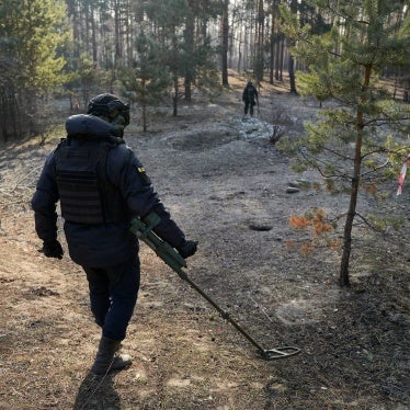 A demining team walking in a forest