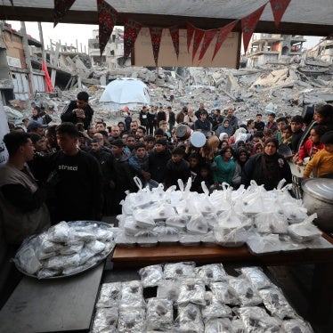 Palestinians wait in line to receive hot food at Jabalia refugee camp in Gaza on March 4, 2025.