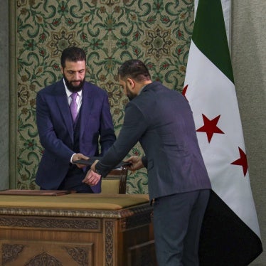 Syria's interim President Ahmad al-Sharaa, center, prepares to sign a constitutional declaration for Syria in Damascus, on March 13, 2025.