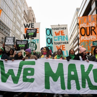 Demonstrators carry signs during The People’s March