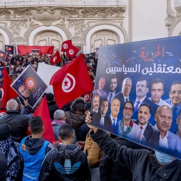Protesters hold up placards and Tunisian flags