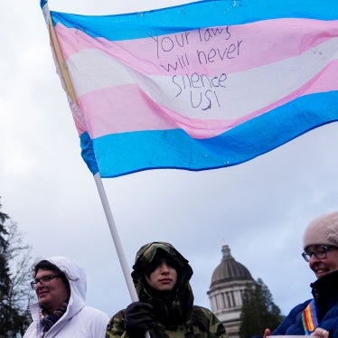 Liv Y., center, holds a transgender pride flag as people gather to protest against the Trump administration near the Washington State Capitol building, in Olympia, Washington, February 5, 2025.