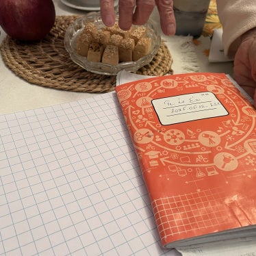 Anna, 80, shows a notebook containing detailed records of monthly expenses, for herself and her sister Erika, 84, in their home in Budapest, Hungary, October 2025.