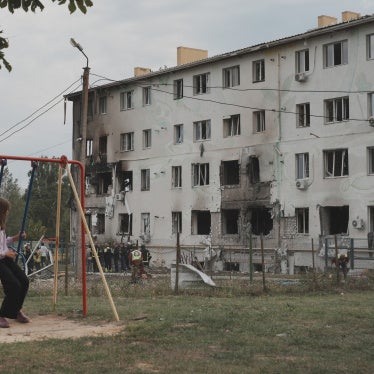 A girl on a swing looks at an apartment building in the Industrialnyi district of Kharkiv, Ukraine, damaged by a Russian drone attack that killed 7 people (including children) and injured 23, on August 18, 2025.