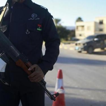 A security officer stands with his weapon on a road leading to a police station in Benghazi December 4, 2014. 