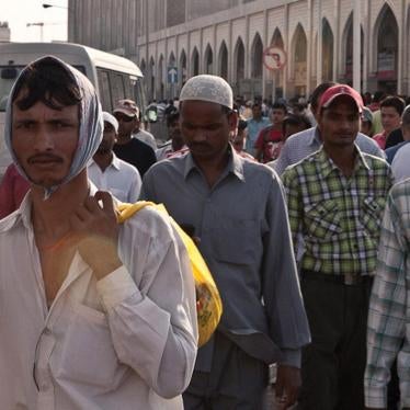 Migrant workers gather on “Bank Street,” in downtown Doha, where many workers wire remittance money to their families in their home countries. 