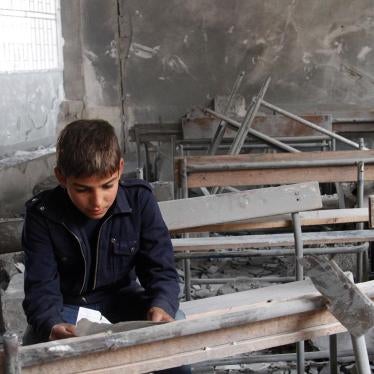 A boy sits inside his now-destroyed former classroom in Aleppo, Syria.