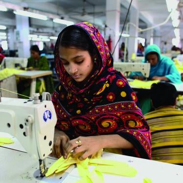 A garment worker sews clothing in a building near the site of the Rana Plaza building collapse. 