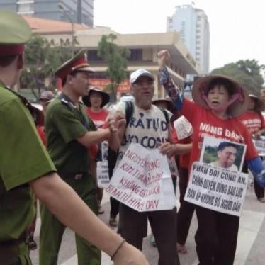 Can Thi Theu protests against police violence. In the photo, she carried a picture of her son Trinh Ba Tu attacked by pro-government thugs in June 2015.