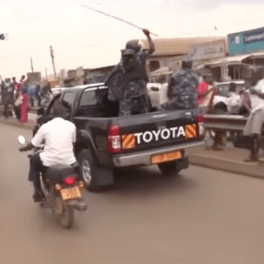 A still from video shows security forces caning and beating supporters of Dr. Kizza Besigye as they gathered to see him on his way home from prison, following his bail.