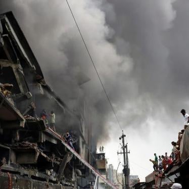 People look at a fire at a food and cigarette packaging factory outside Dhaka, Bangladesh, September 10, 2016.
