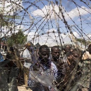 Somali refugees look through a barbed wire fence in Dadaab in 2013.