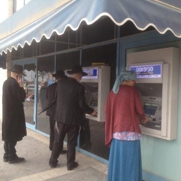 Customers use ATMs outside a bank branch in the Israeli settlement of Modi'in Ilit.