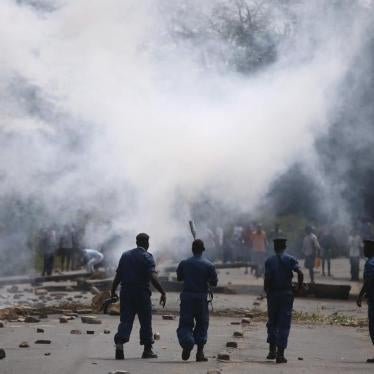 Policemen walk after they fire tear gas canisters at protesters during a protest against Burundi President Pierre Nkurunziza and his bid for a third term in Bujumbura, Burundi, May 21, 2015.       